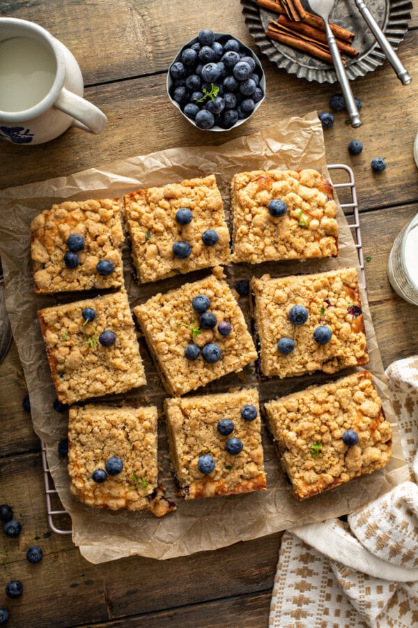 A coffee cake cut up into slices on parchment paper. 