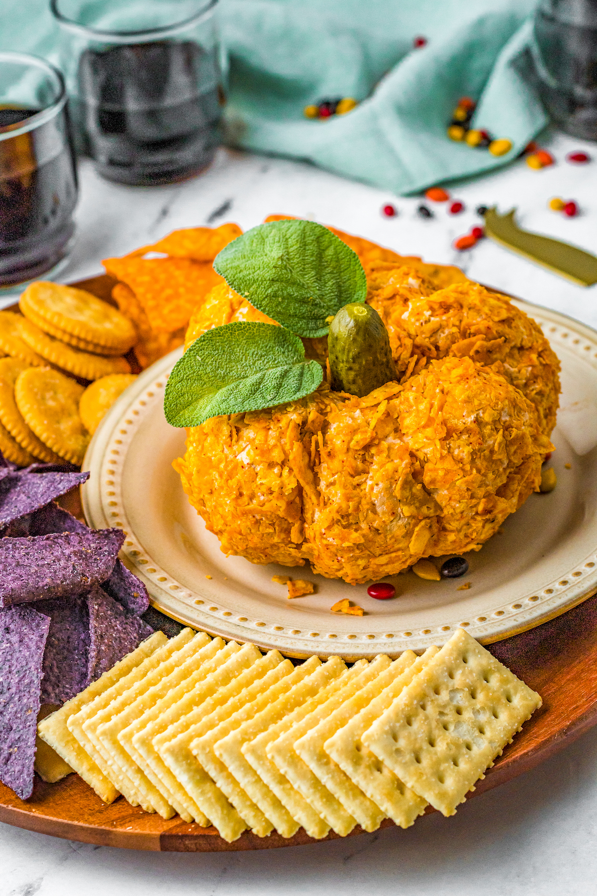 Pumpkin cheese ball on a plate with crackers.