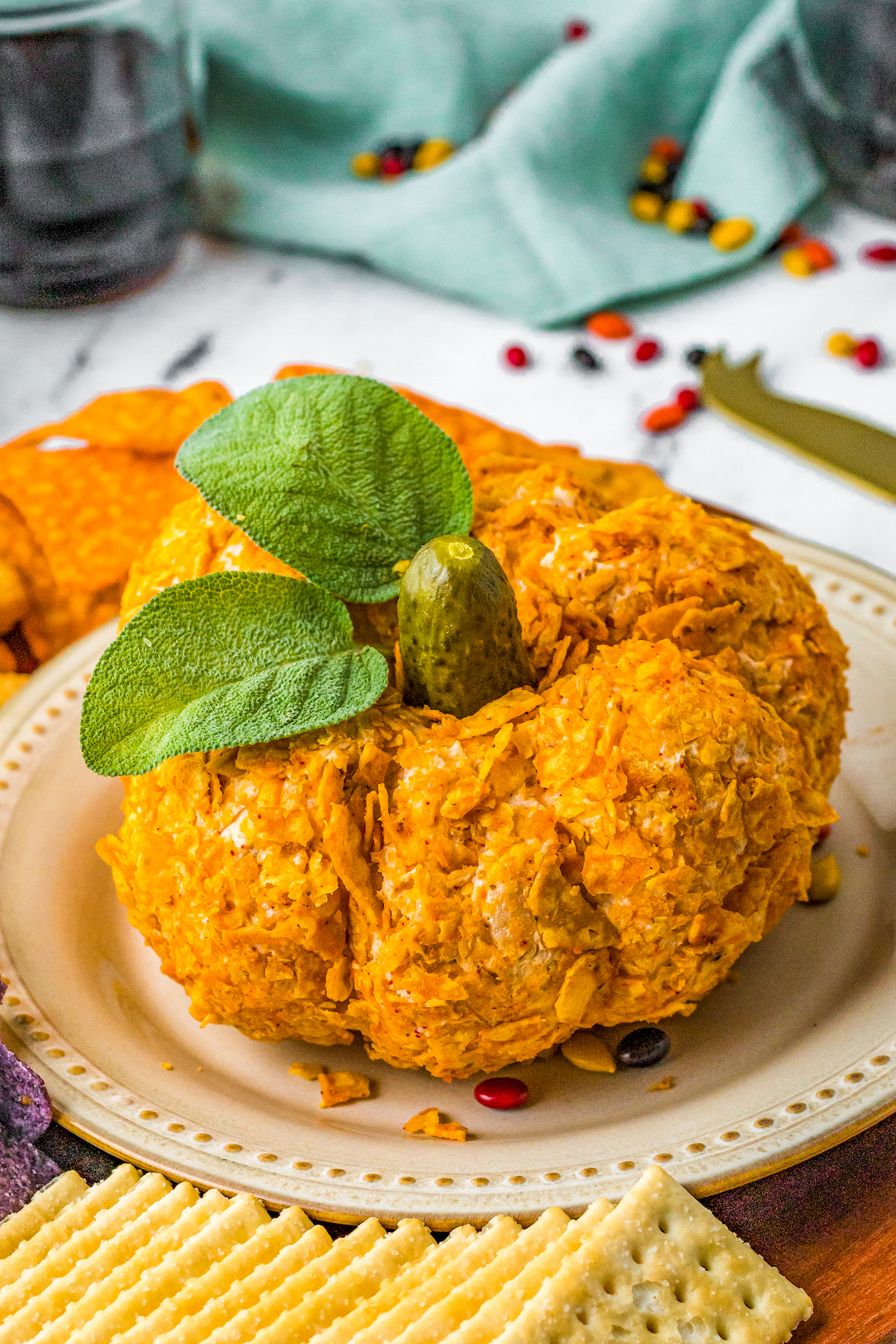 A pumpkin cheese ball with a pickle for a stem, and leaves.