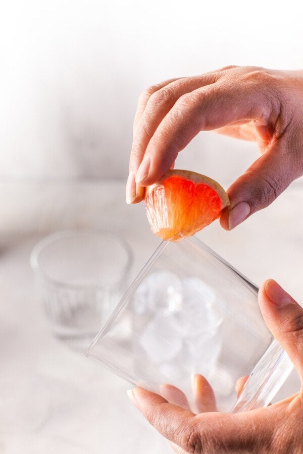 Grapefruit wedge wetting the rim of a glass.