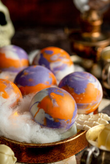 Orange, purple, and white hot cocoa bombs.