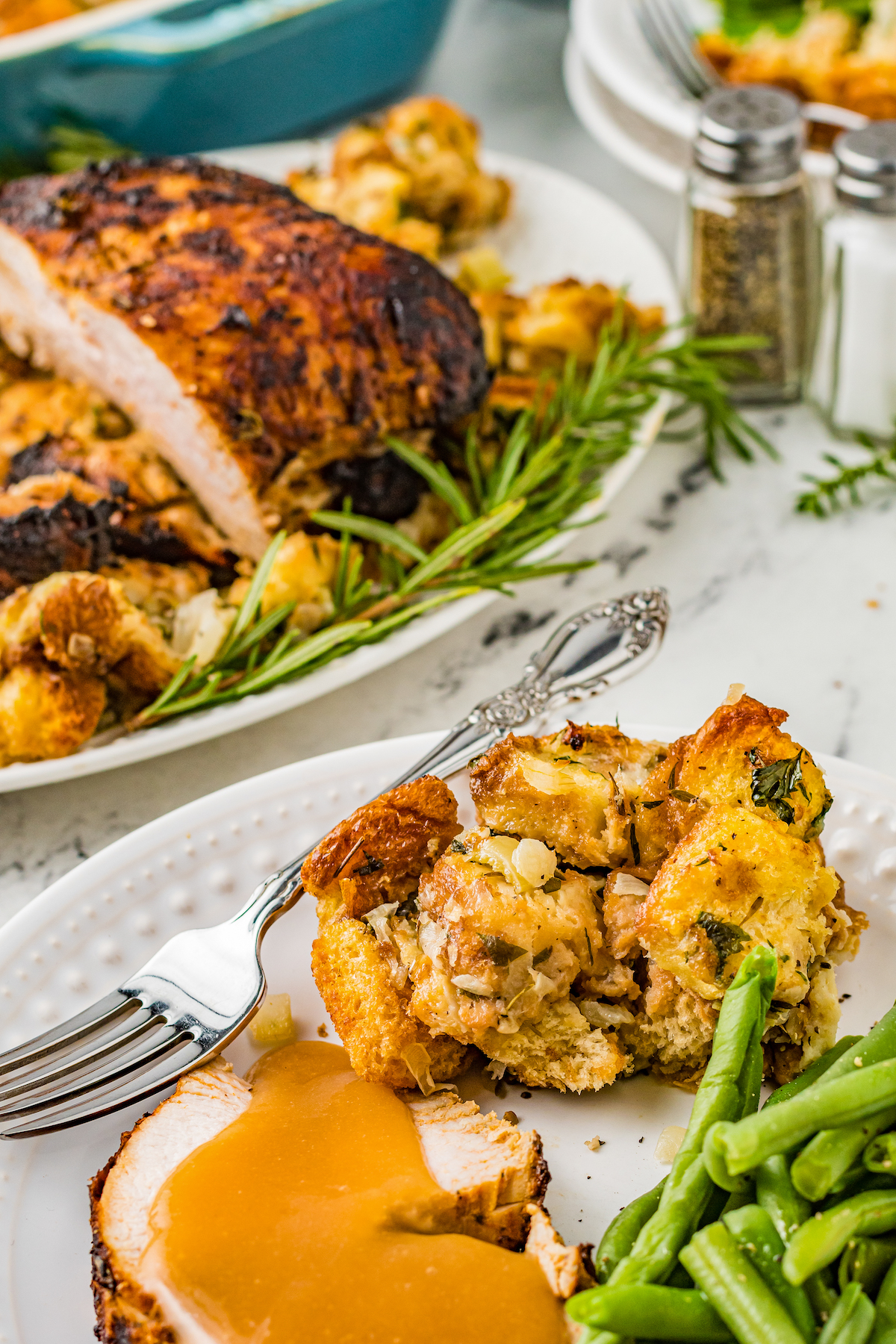 A plate of turkey, gravy, green beans, and stuffing.
