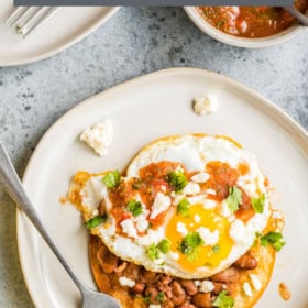 Huevos Rancheros on a white plate with a fork.