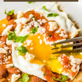 Up close image of Huevos Rancheros with the yolk broken with a fork.