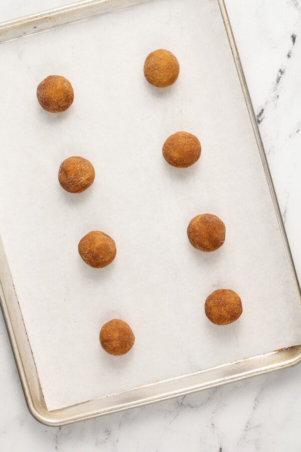 A baking sheet of pumpkin cookie dough balls.