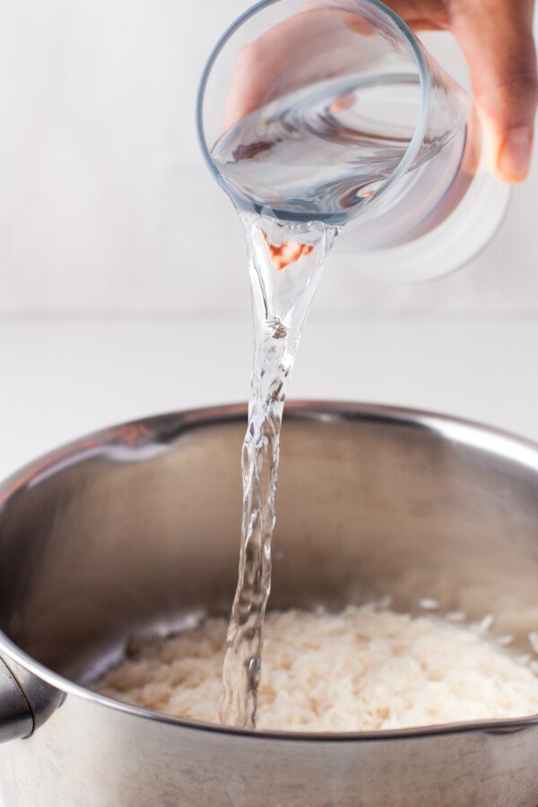 Water poured over rice in a saucepan.