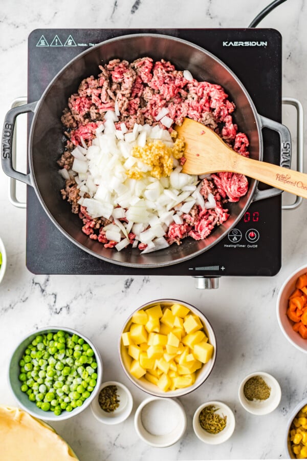 Ground beef, onions, and seasonings in a skillet.