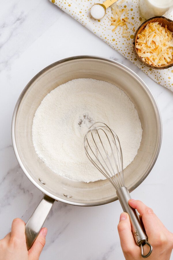 The dry coconut cream pie filling ingredients are combined and whisked in a saucepan.
