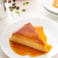 A slice of flan on a white plate.