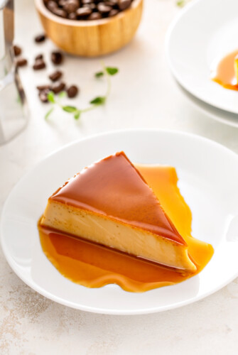 A slice of flan on a white plate.