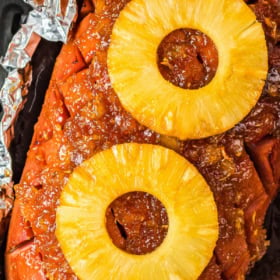 A ham in an air fryer with foil on top.