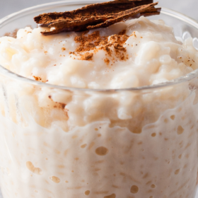 Arroz Con Leche in a glass jar with cinnamon on top.