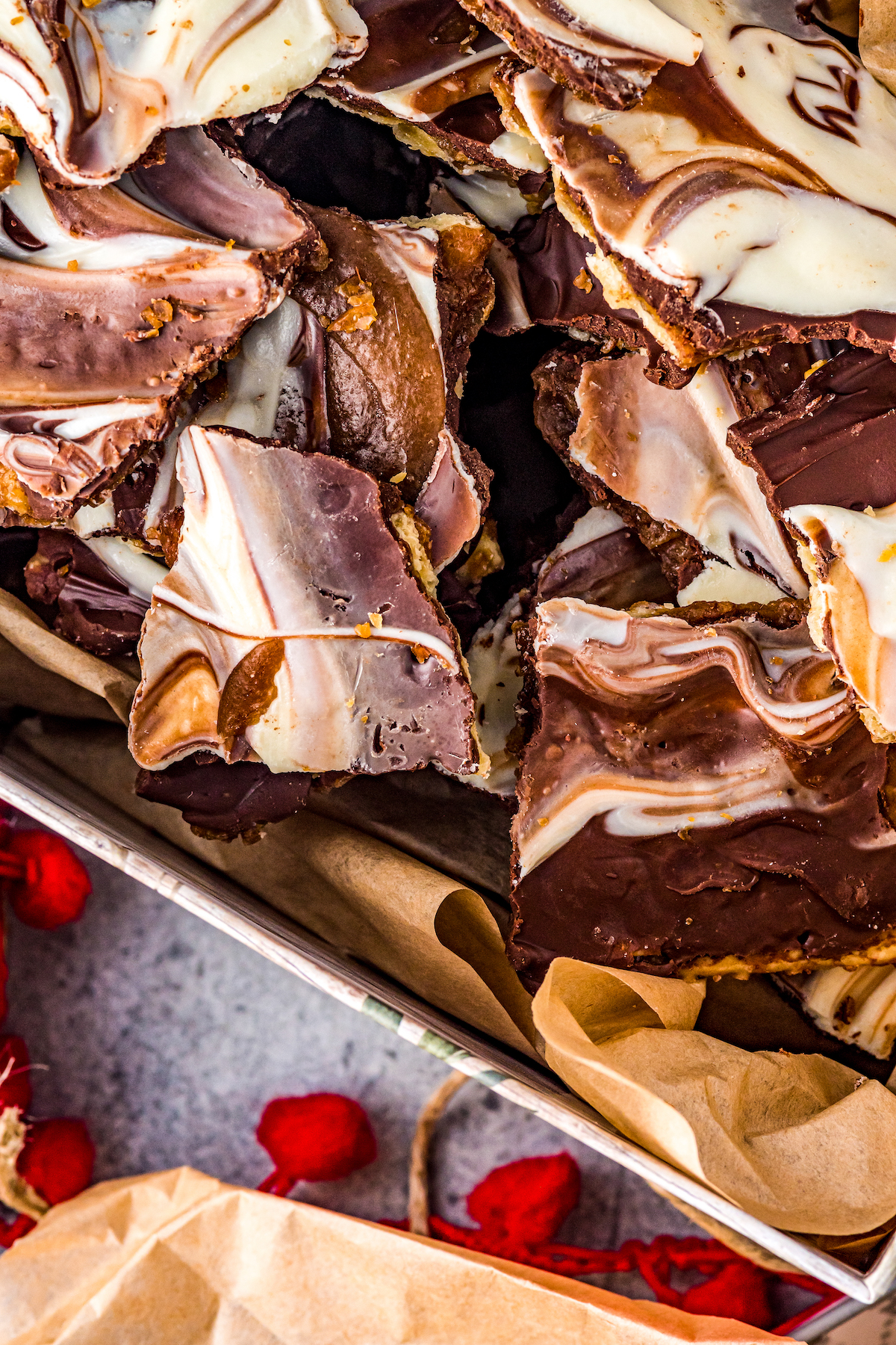 Saltine toffee candy topped with marbled chocolate, on a square white serving plate.