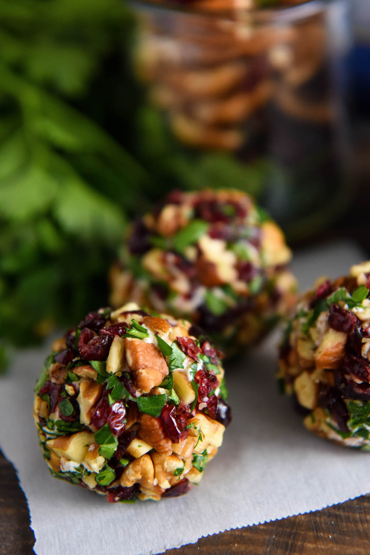 Up close image of goat cheese truffle rolled in pecans, dried cranberries and parsley.