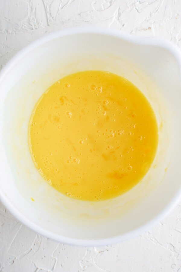 Beaten eggs in a mixing bowl.