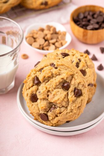 Peanut butter chocolate chip cookies on a plate with a glass of milk.