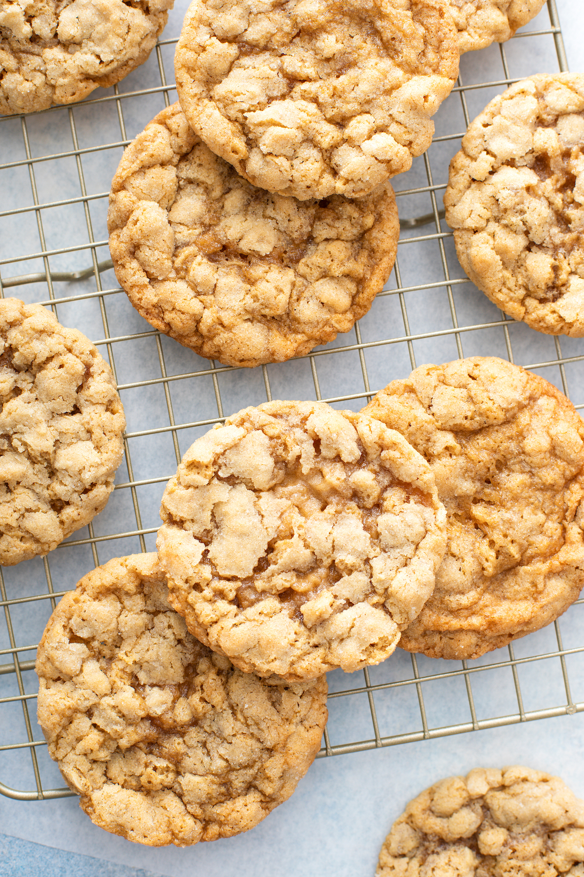 Seven peanut butter oatmeal cookies heaped on a baking rack.