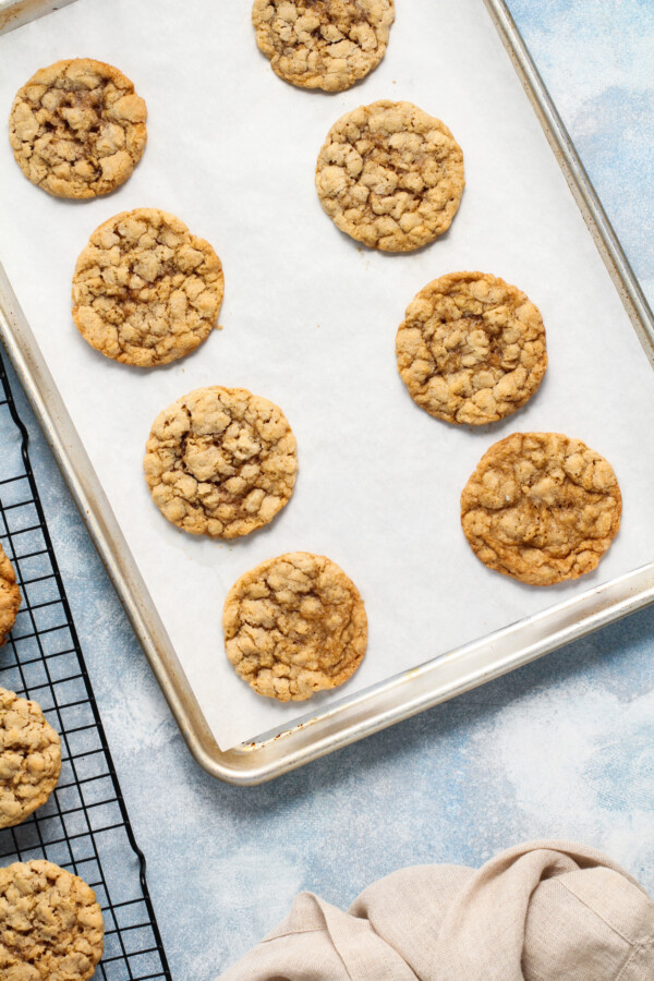 Baked peanut butter oatmeal cookies on a cookie sheet.