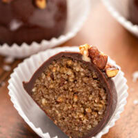 Up close image of a pecan pie truffle sliced in half to show the bourbon pecan pie filling.
