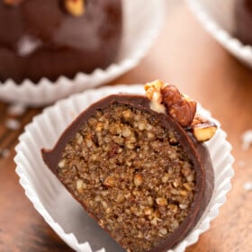Up close image of a pecan pie truffle sliced in half to show the bourbon pecan pie filling.
