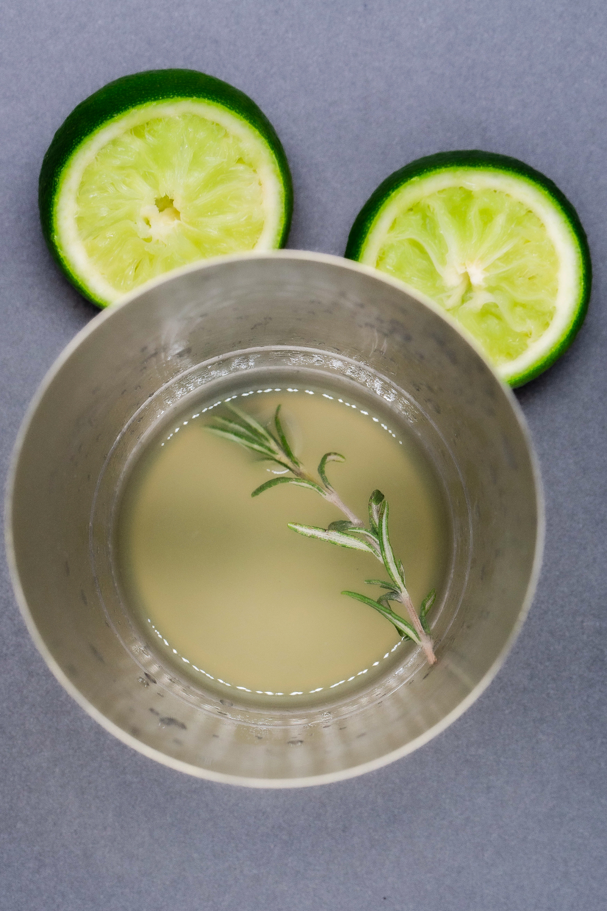 Lime juice, rosemary, and tequila macerating in a shaker.