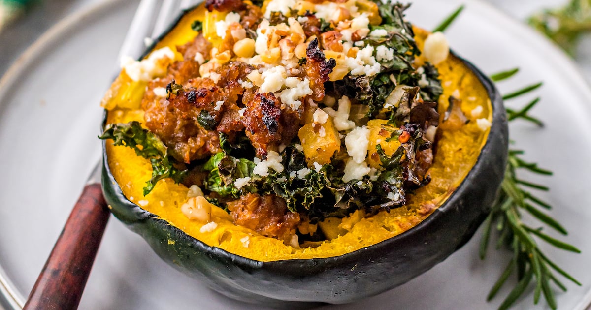 Up close image of a side view of stuffed acorn squash with the filling inside.