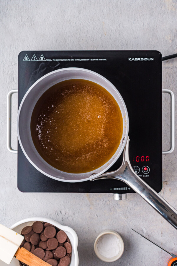 An overhead shot of golden candy syrup bubbling in a saucepan.