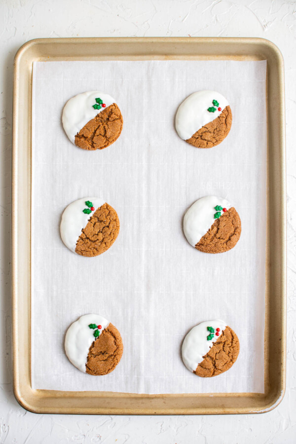 Gingersnap cookies set on a cookie sheet with parchment paper.