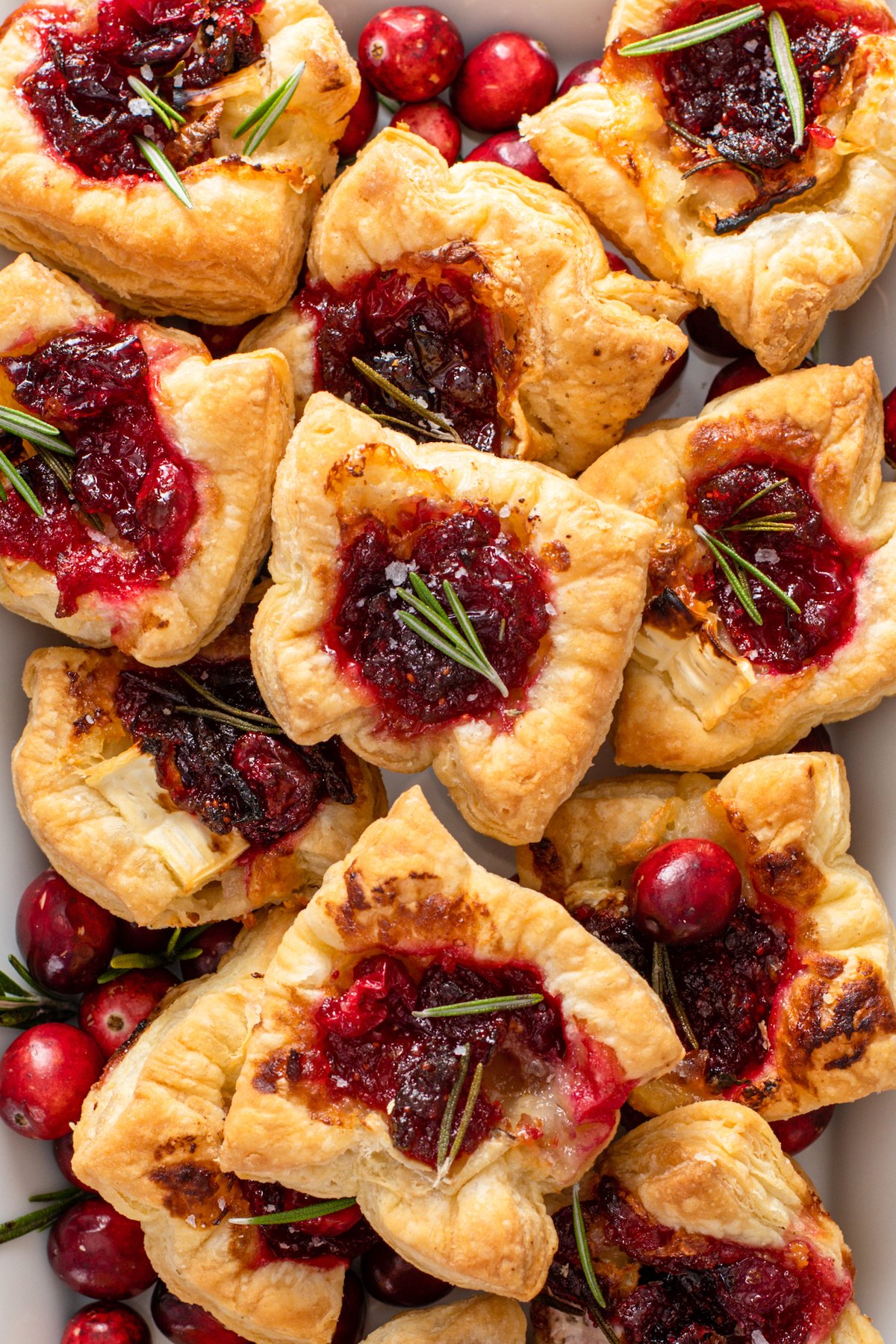 Up close image of cranberry Brie Bites Christmas appetizer with rosemary on top.