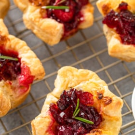 Cranberry brie bite on a cooling rack with rosemary.