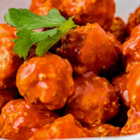Close-up shot of chicken meatballs with buffalo sauce.