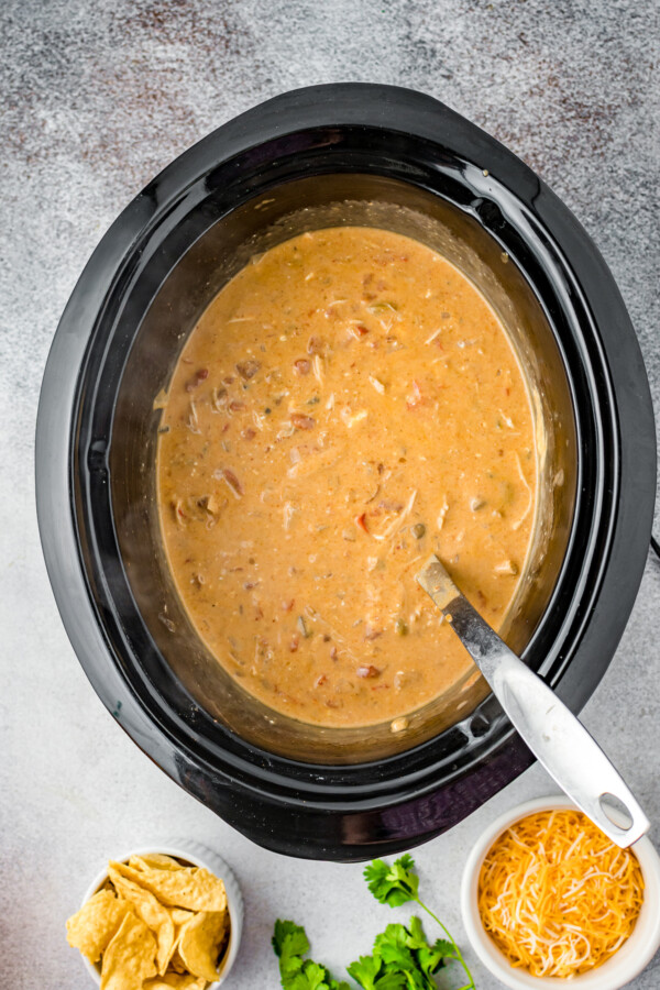Overhead shot of a crockpot insert filled with creamy King Ranch chicken soup.