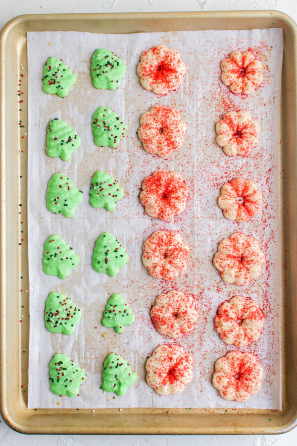 Spritz cookies baked on parchment paper on a cookie sheet.