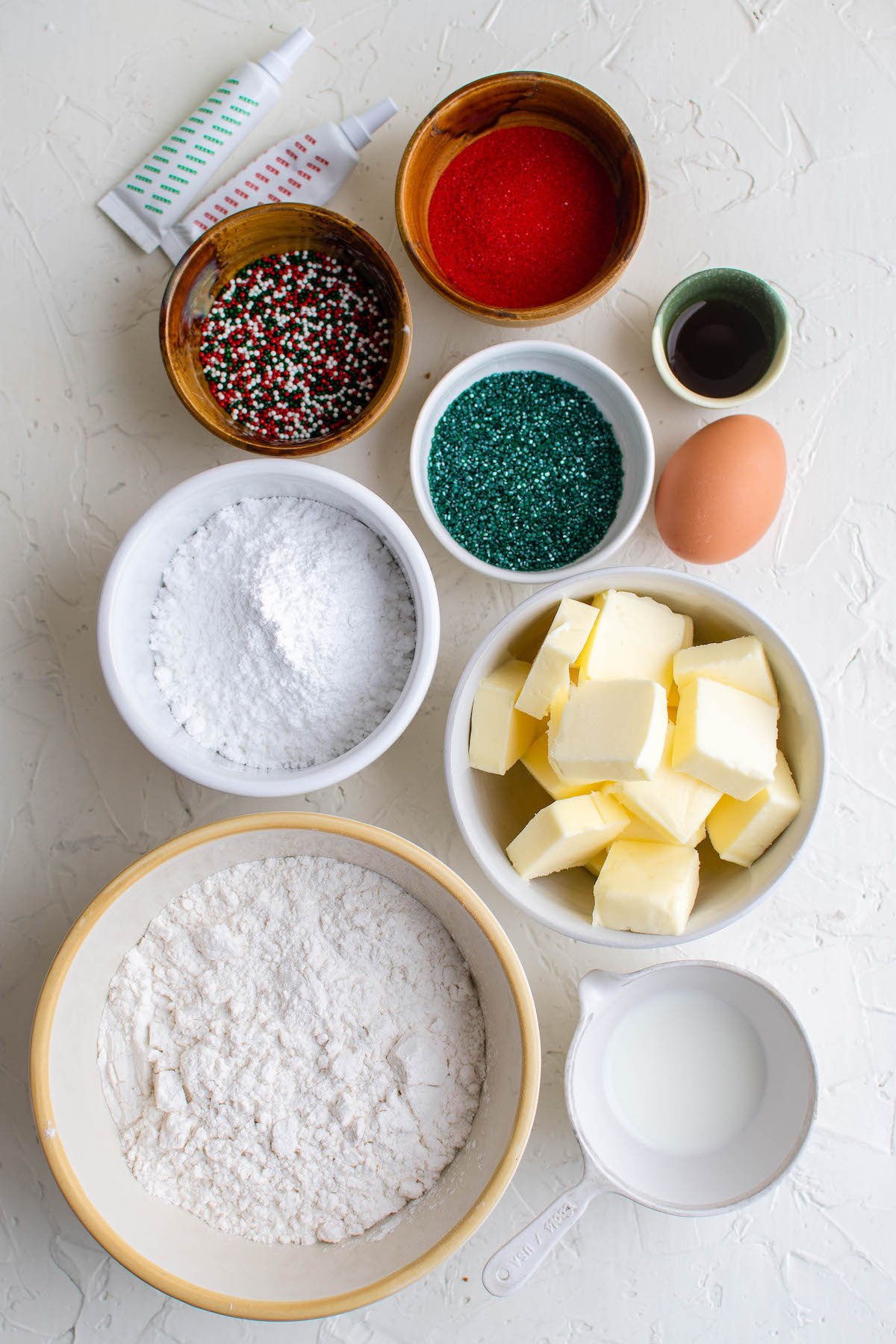 Ingredients for spritz cookies in white bowls.