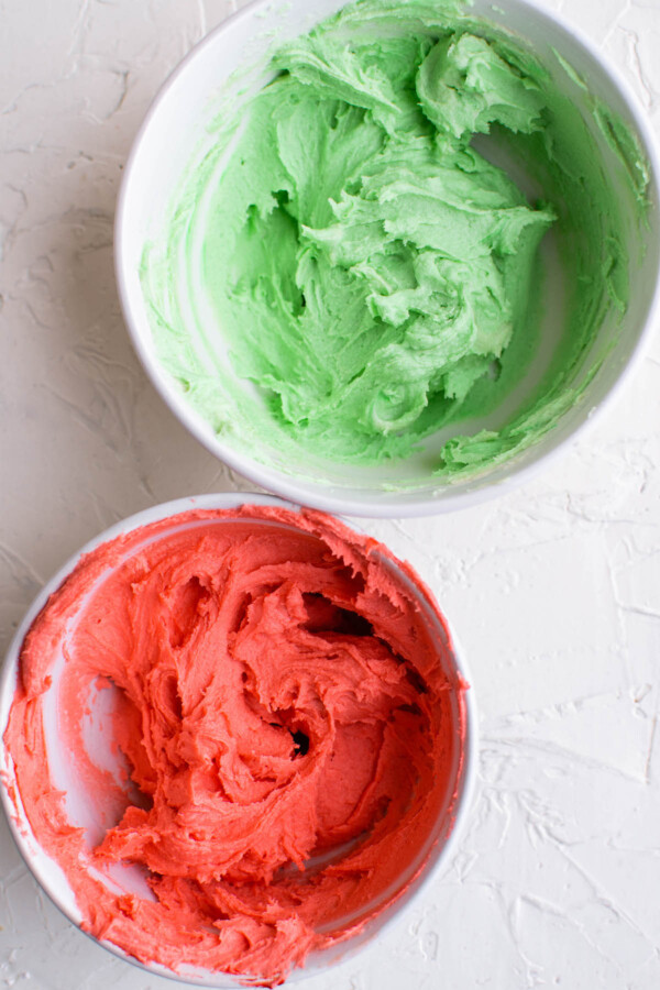 White bowls filled with red and green cookie dough.