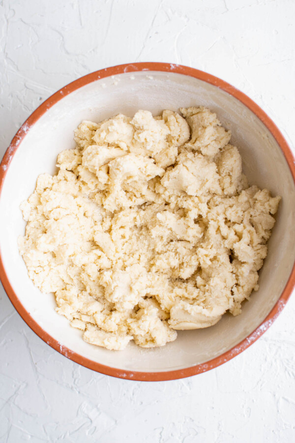 A bowl full of sugar cookie dough on a white background.