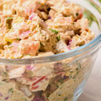 A side view of tuna salad in a large glass bowl.