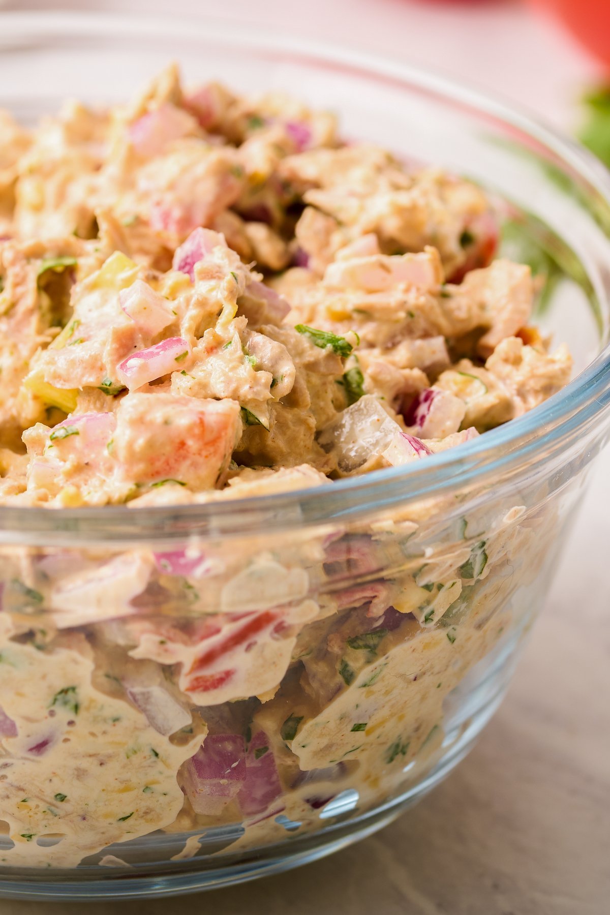 A side view of tuna salad in a large glass bowl.