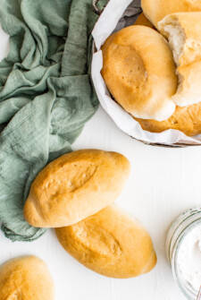 Bread rolls on a table, with a green cloth napkin.