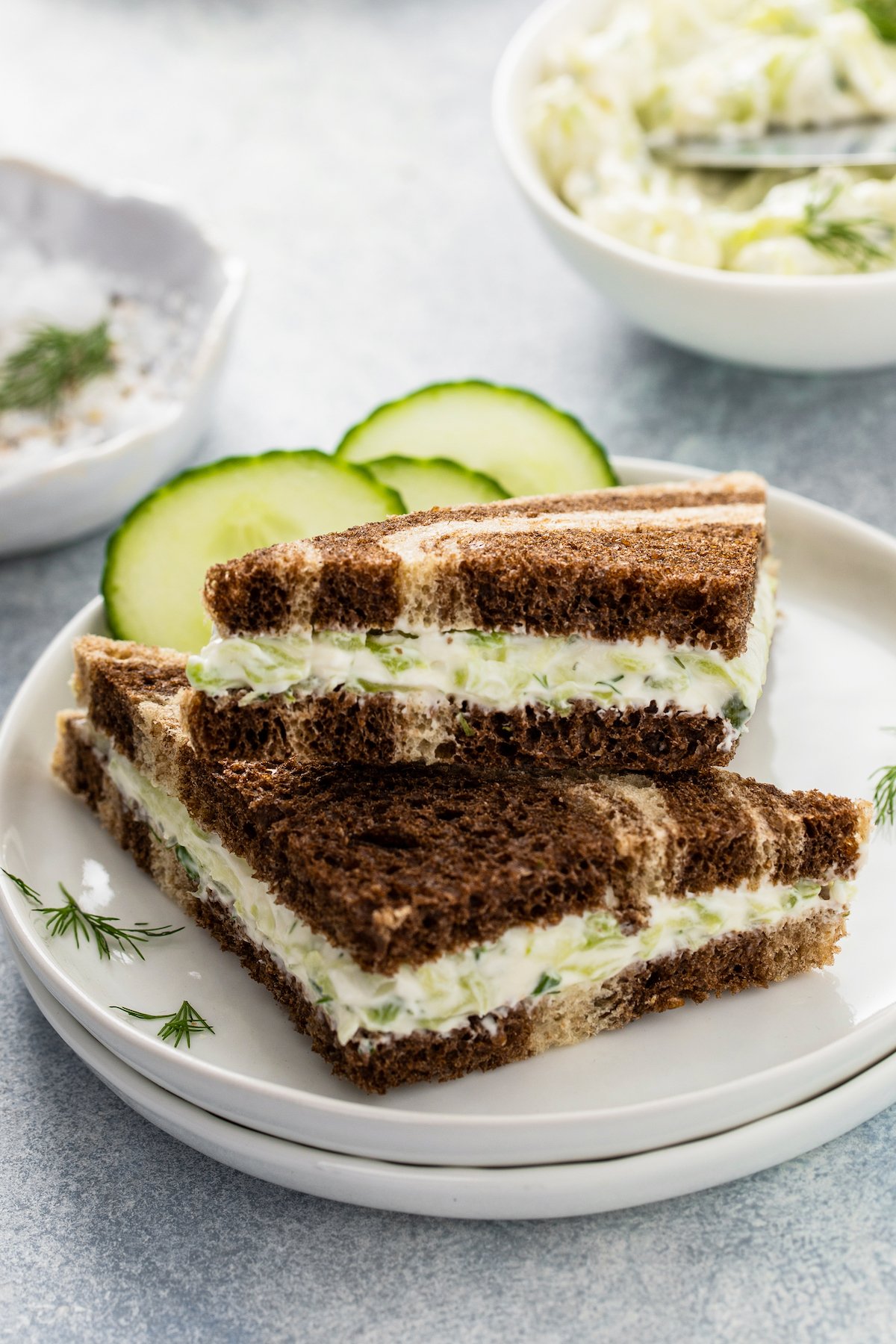 Triangular cucumber sandwiches on a plate.