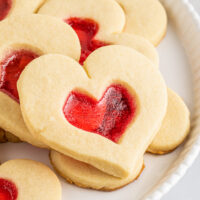 Sugar cookies with red candy centers on a plate.