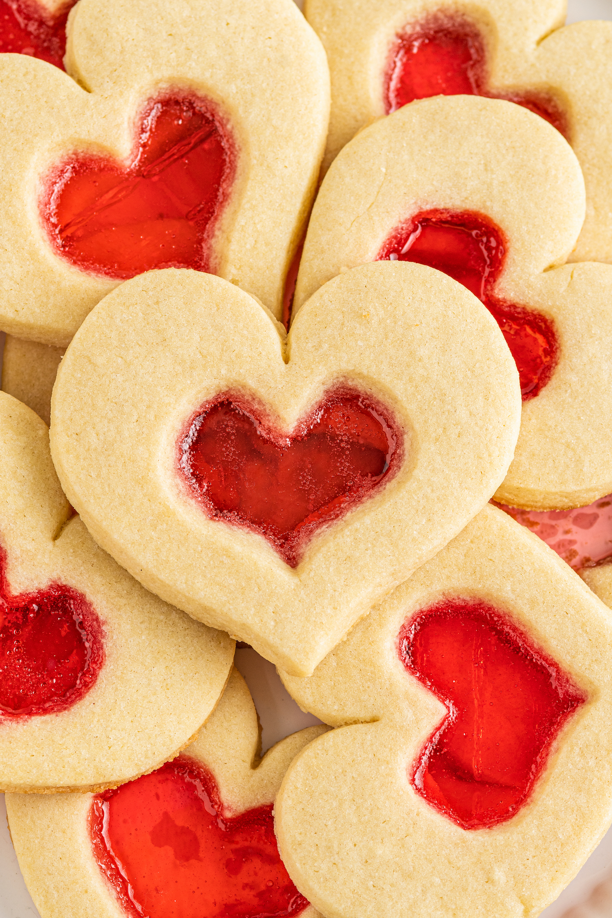 Close-up shot of heart-shaped cookies with red centers.