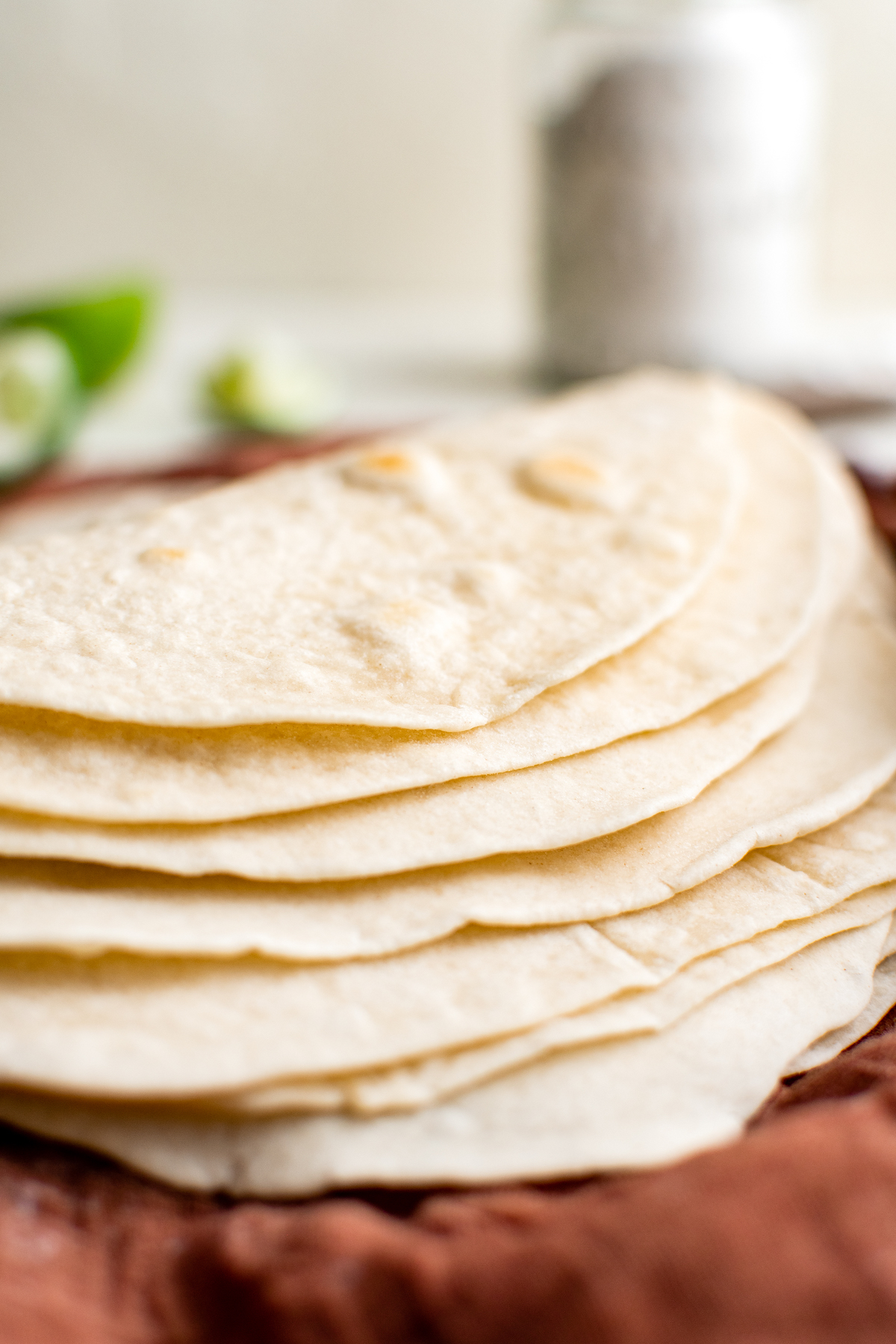A close-up side view of flour tortillas fanned out on a napkin.