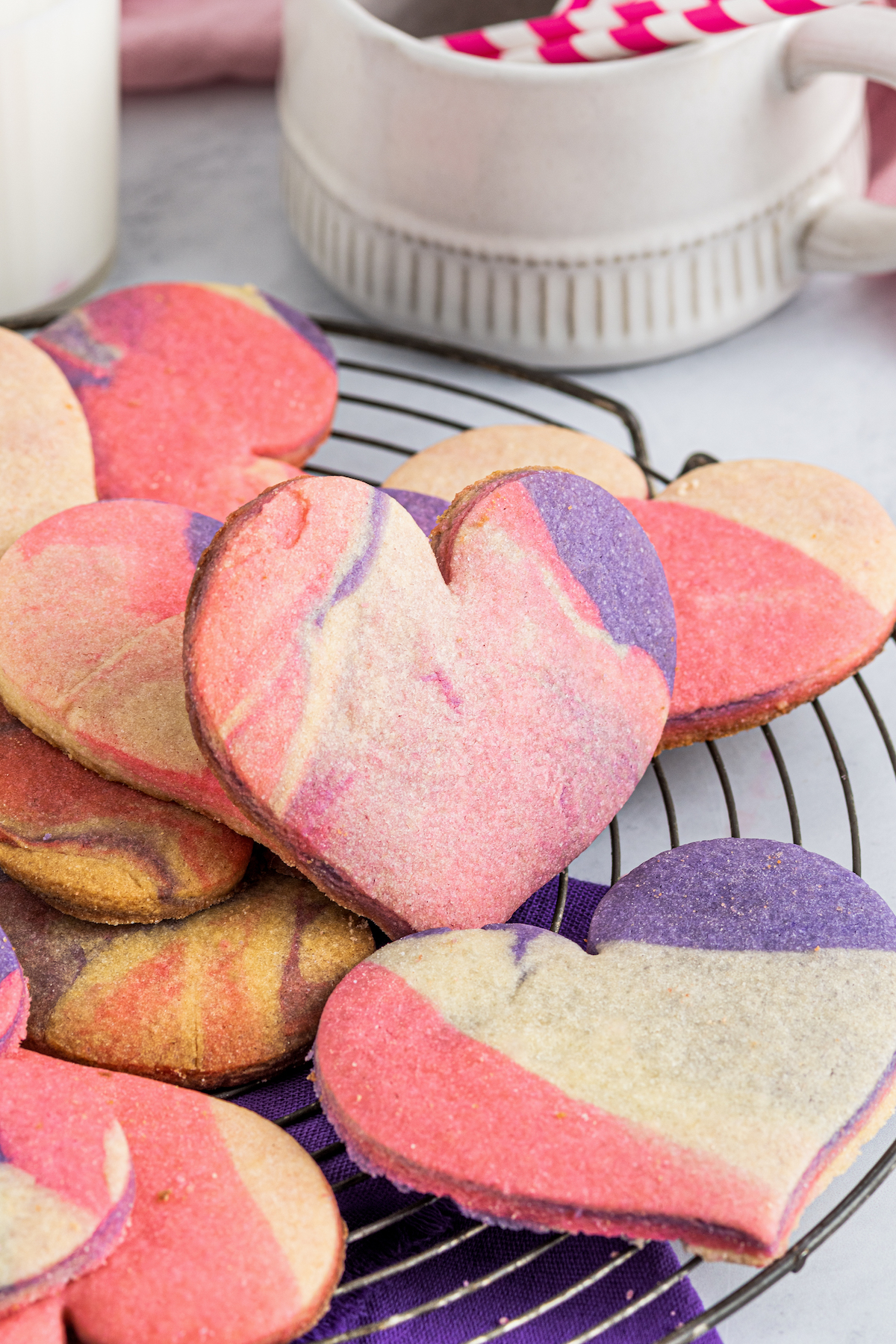 Heart-shaped marbled sugar cookies on a wire rack.