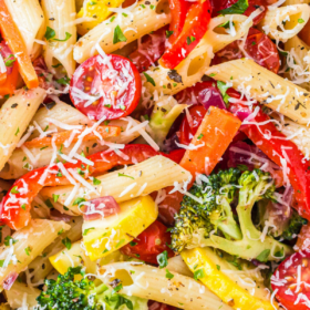 Rainbow vegetables with pasta with parmesan cheese sprinkled on top.