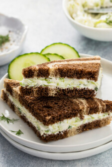 Triangular cucumber sandwiches on a plate.