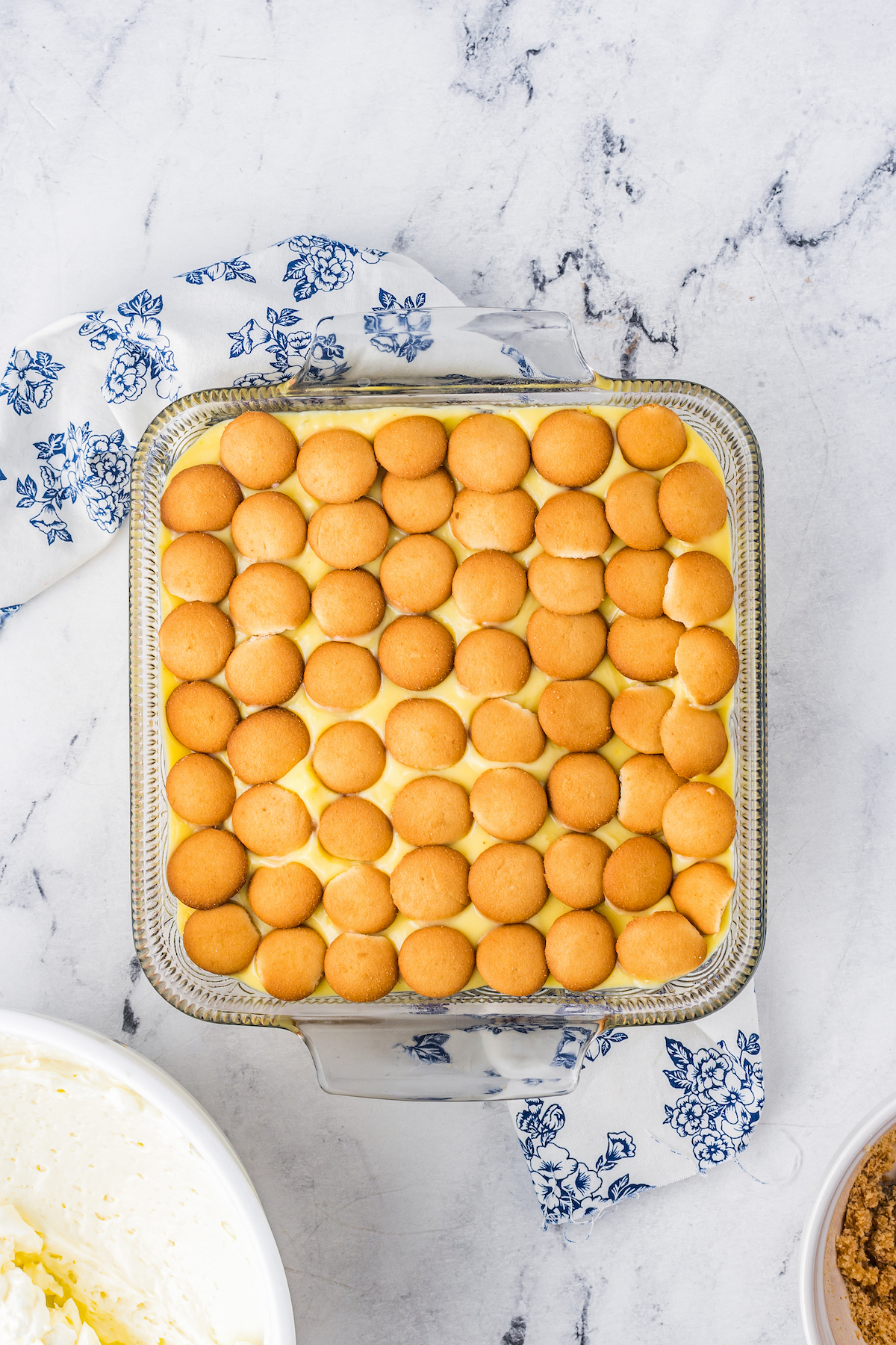 Overhead shot of Nilla Wafers and pudding in a glass baking pan.