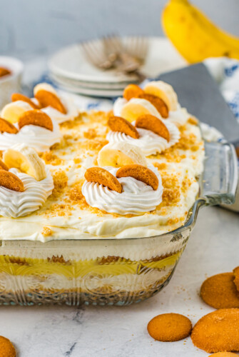 Banana pudding in a glass baking dish, viewed from the side to show the layers.
