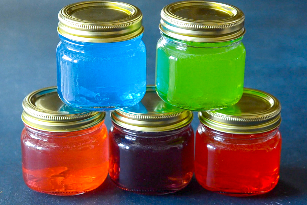 Five jars of jolly rancher vodka stacked on top of each other for a jolly rancher shot. 