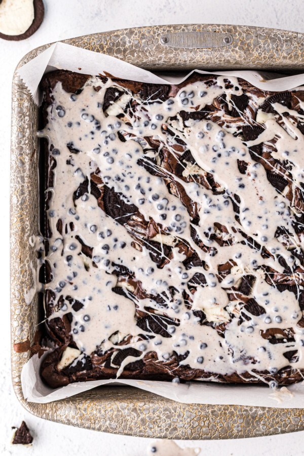 A pan of brownies topped with melted white chocolate candy mixture.